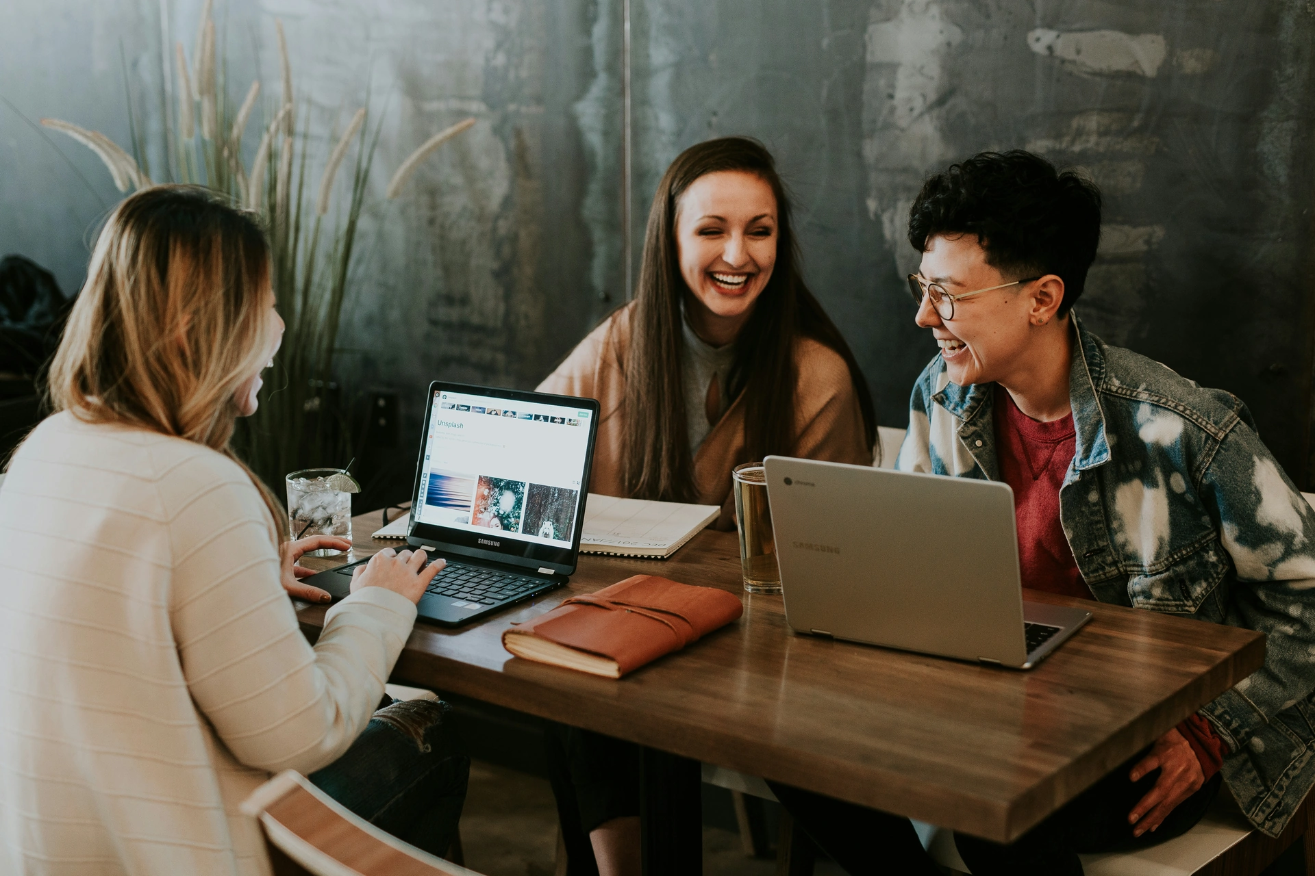 Personas comparten ideas alrededor de una mesa con portátiles